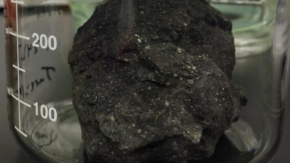 A piece of meteorite inside a glass jar.